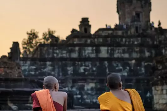 Monjes budistas descansando fuera dedel templo de Bakong, Camboya